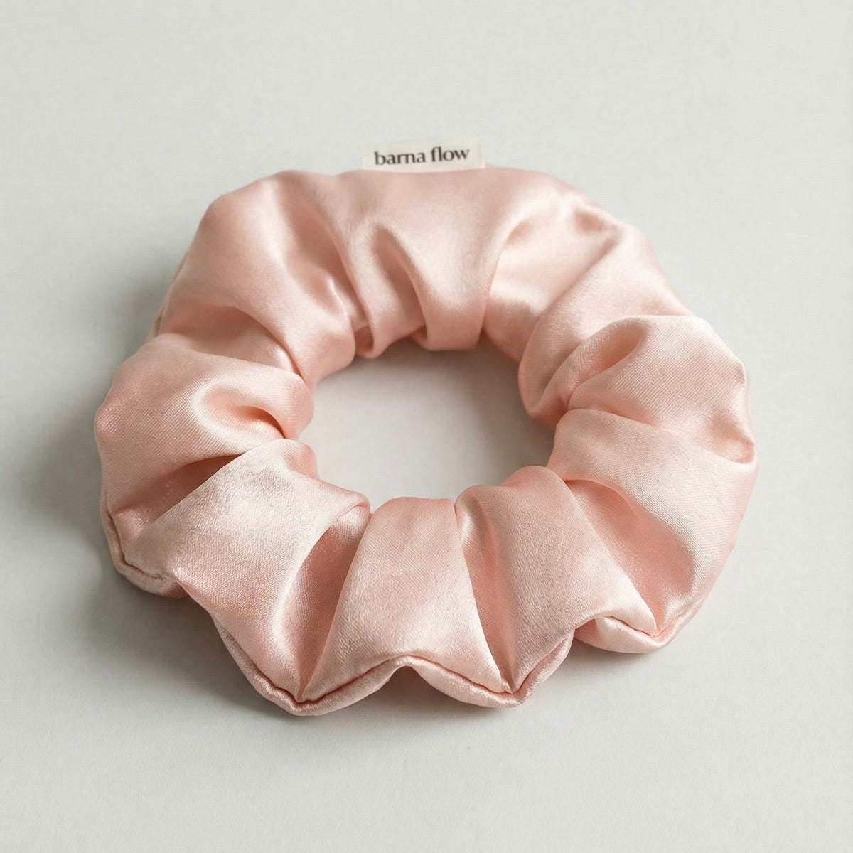 Pink silk scrunchie on a light gray background