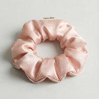Pink silk scrunchie on a light gray background