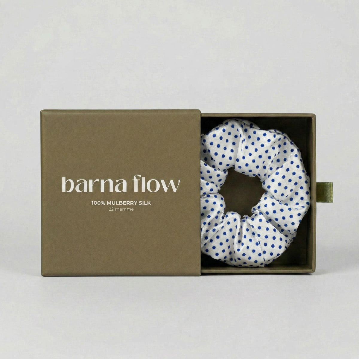 Silk scrunchie in a 'barna flow' box on a light gray background