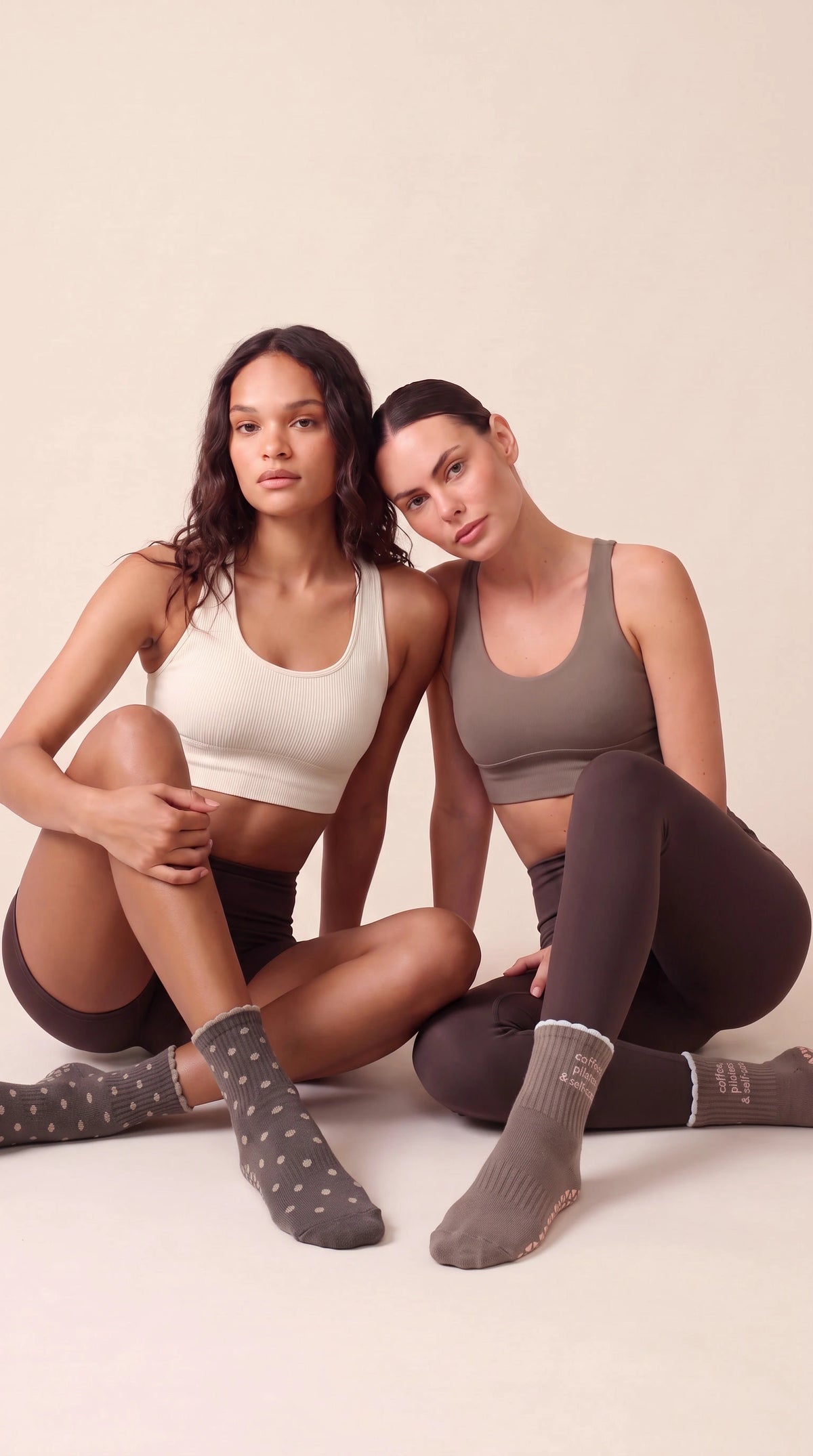 Beine in rosa barna flow Anti-Rutsch-Socken, ausgestreckt auf einem Pilates-Reformer