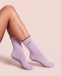 Legs crossed, wearing You Can Do It Pilates Grip Socks
