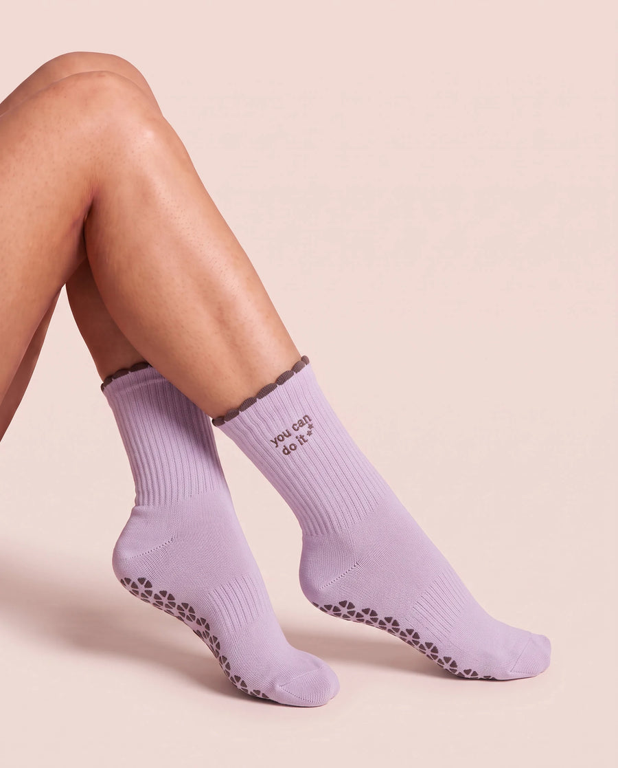 Legs crossed, wearing You Can Do It Pilates Grip Socks